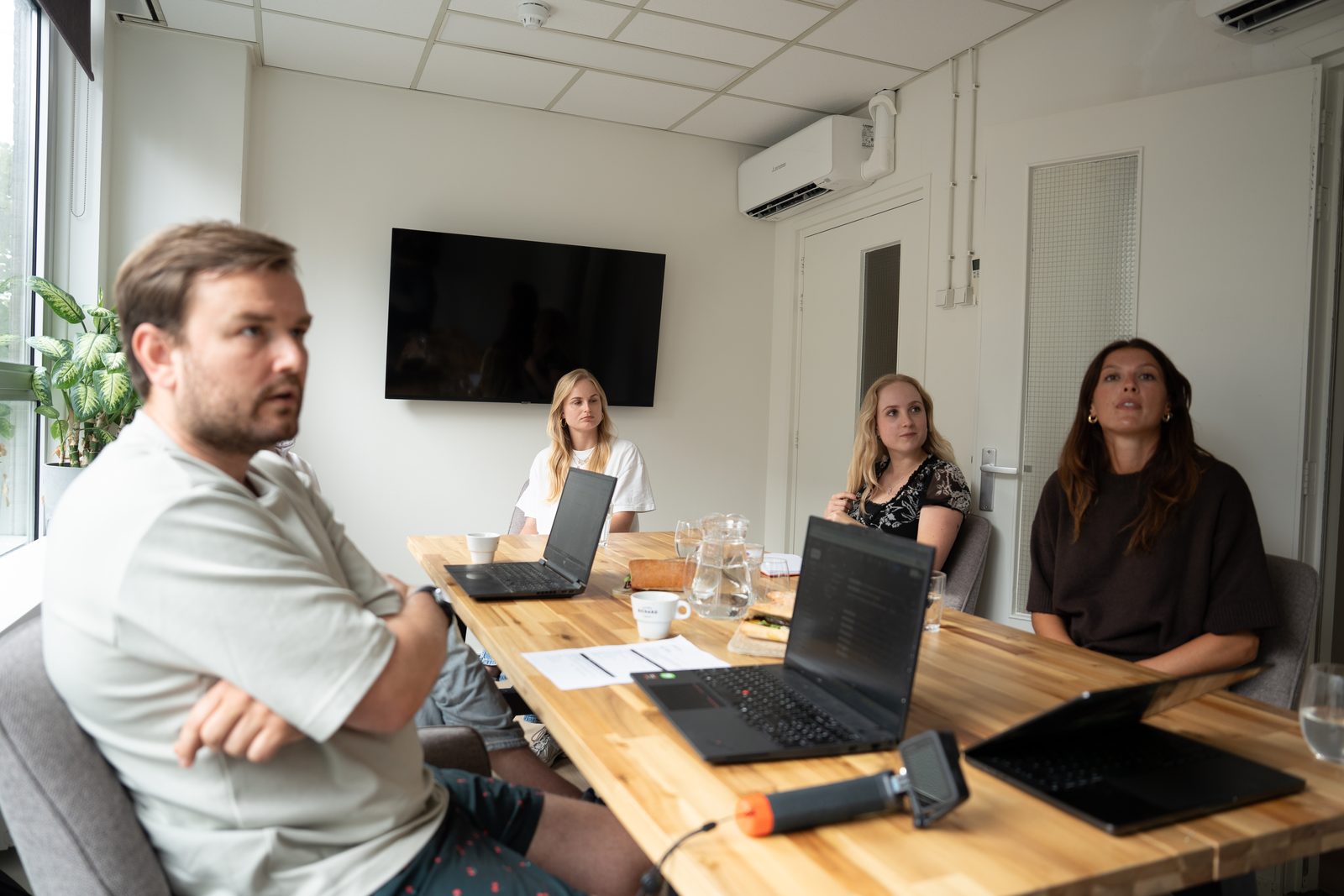 Boyd van Webnexus in gesprek met ondernemers aan een vergadertafel met laptops