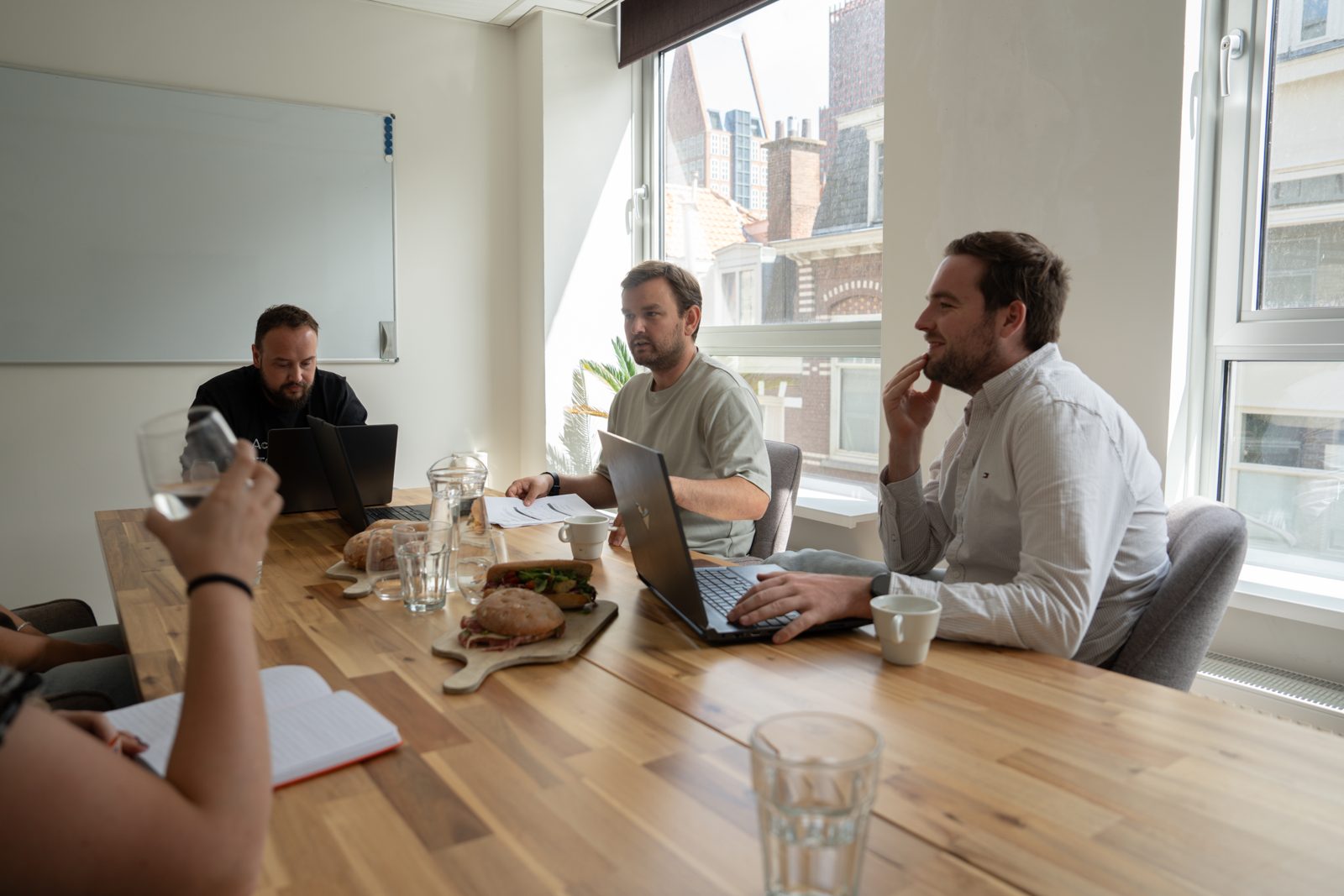 Een groep mensen in overleg aan tafel met laptops tijdens een sessie van Webnexus