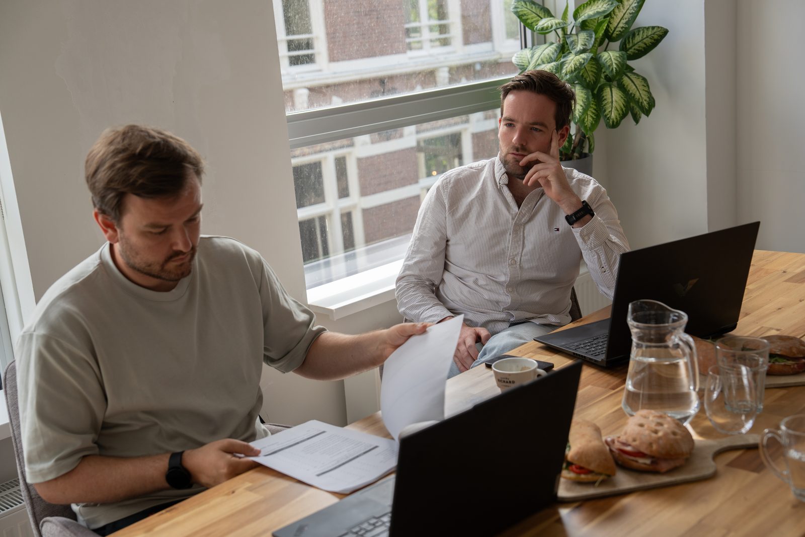 Boyd Belshof en een ondernemer met papieren en een laptop aan tafel tijdens een sessie